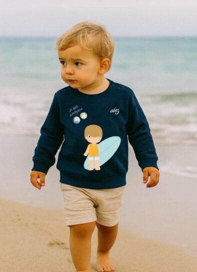 bébé allergique qui marche sur la plage avec un pull de prévention